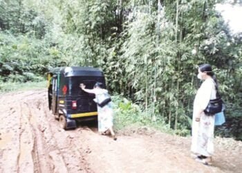 A health worker pushes an auto rickshaw