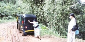 A health worker pushes an auto rickshaw